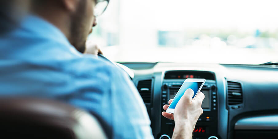 hombre enviando mensajes de texto al volante de un coche